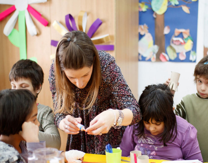 The teacher with children doing art and craft class at a childcare center