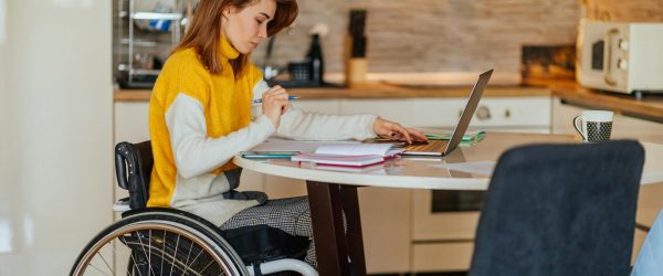 Young woman in wheelchair doing her homework.