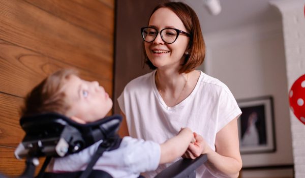 A mom and her young son with cerebral palsy at home